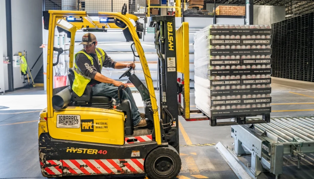 Loading dock worker on forklift with open doors