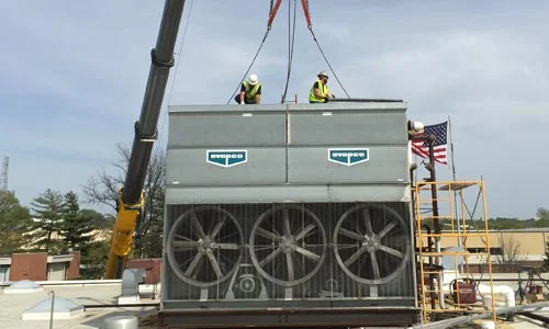 2 HVAC techs placing a roof system on a building